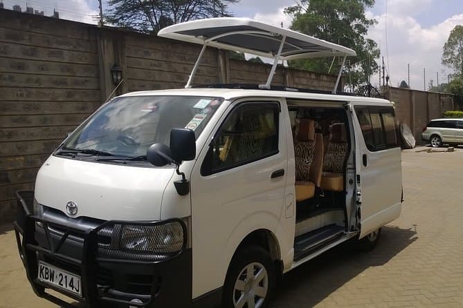 White Toyota HiAce with pop-top roof open, Kenyan plates KBW 214J
